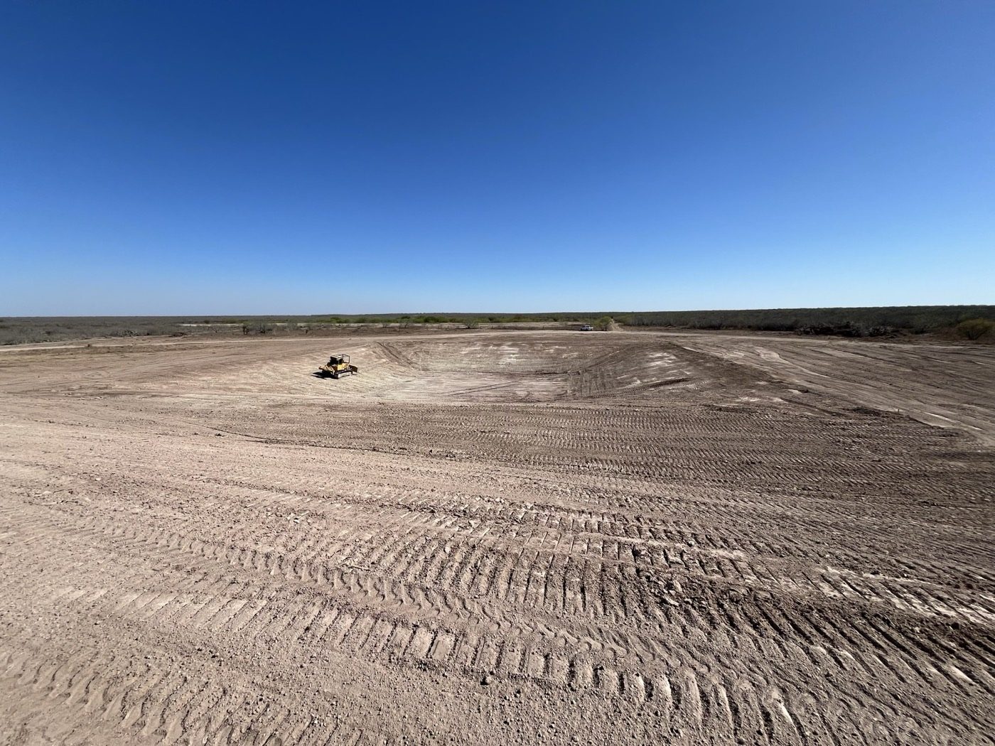 Dozer cutting a large pad out of open ground