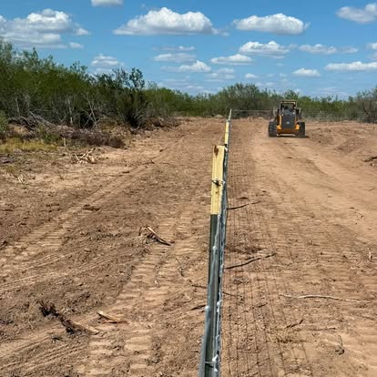 Dozer clearing a fence line through brush