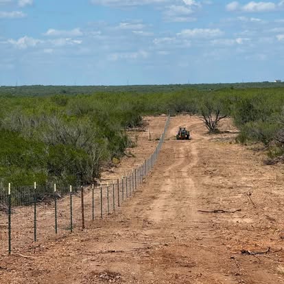 New net wire fence running to the horizon on a cleared line